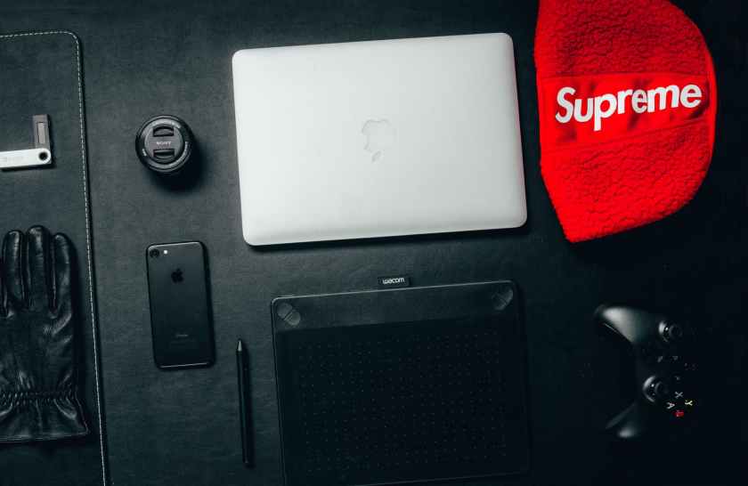 macbook beside red supreme textile